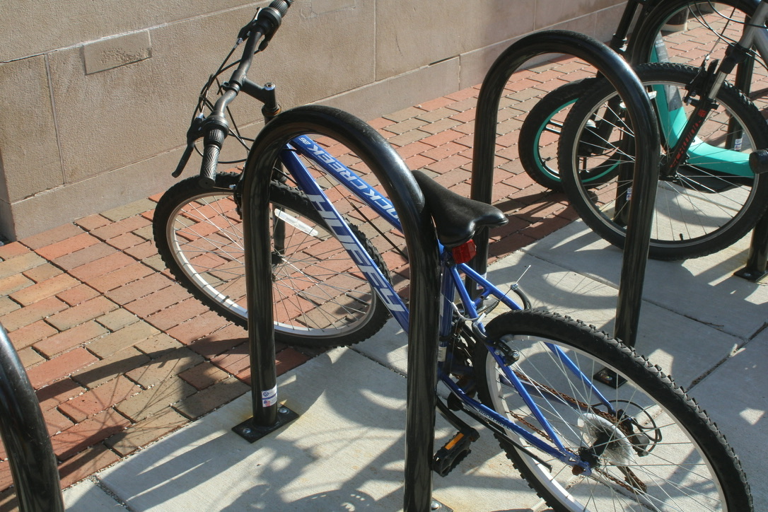 a bike leaning against a rack, no lock