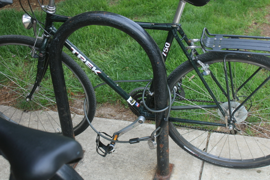 a bike with a chain around the chassis, front, and back wheels, with a master lock holding it together