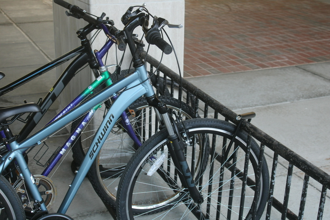 a photo of three bikes, two of which are only locked in the front wheel