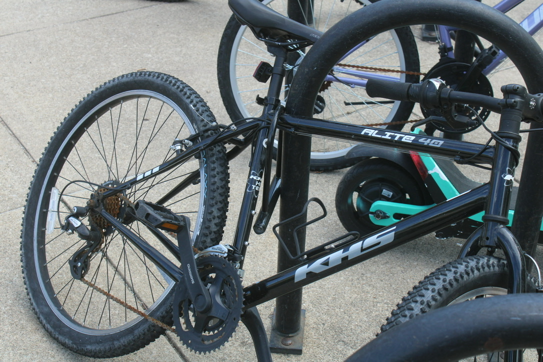 a bike with the lock nearly attached to the rack, but not quite