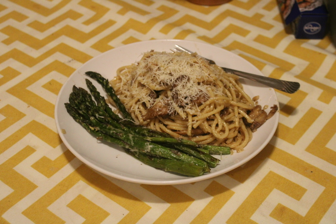 a plate with lions mane and creamy pasta, next to some roasted asparagus